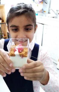 Enfant présentant une verrine réalisée dans le cadre de la découverte du goût